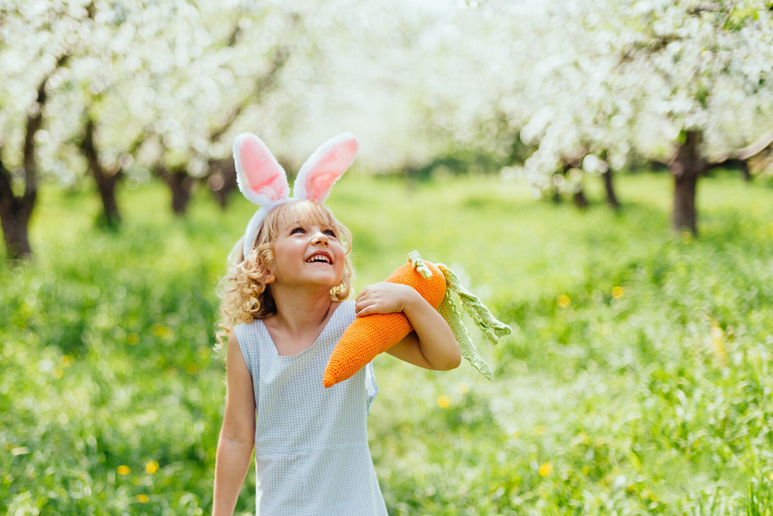 Mädchen auf Wiese am Ostern mit Karotte